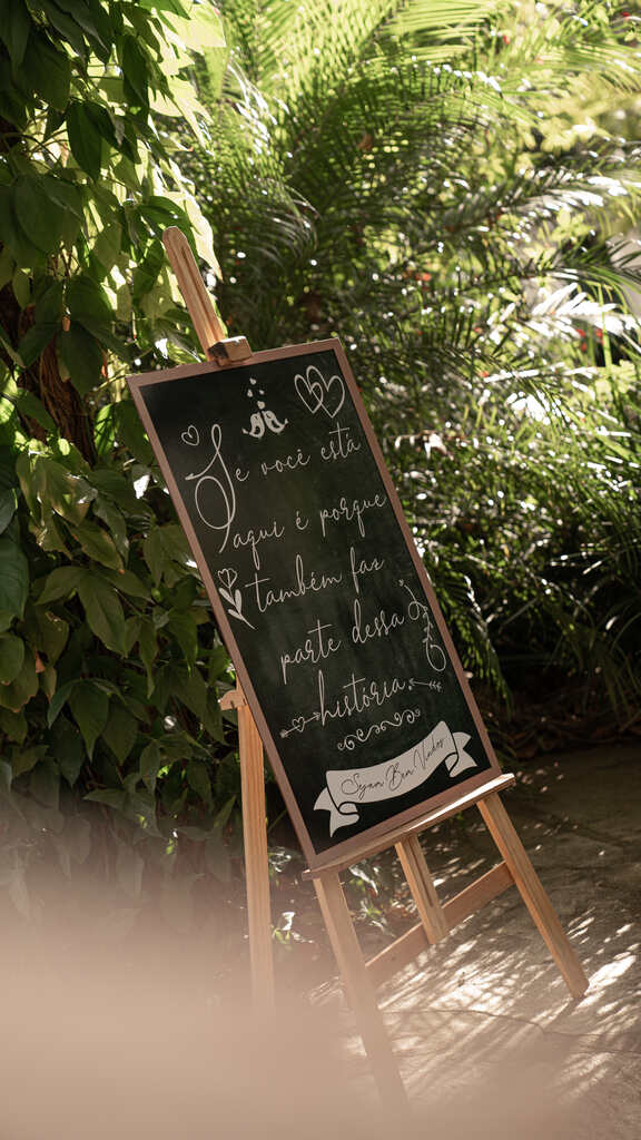 cavalete com quadro de lousa escrito bem-vindos no jardim