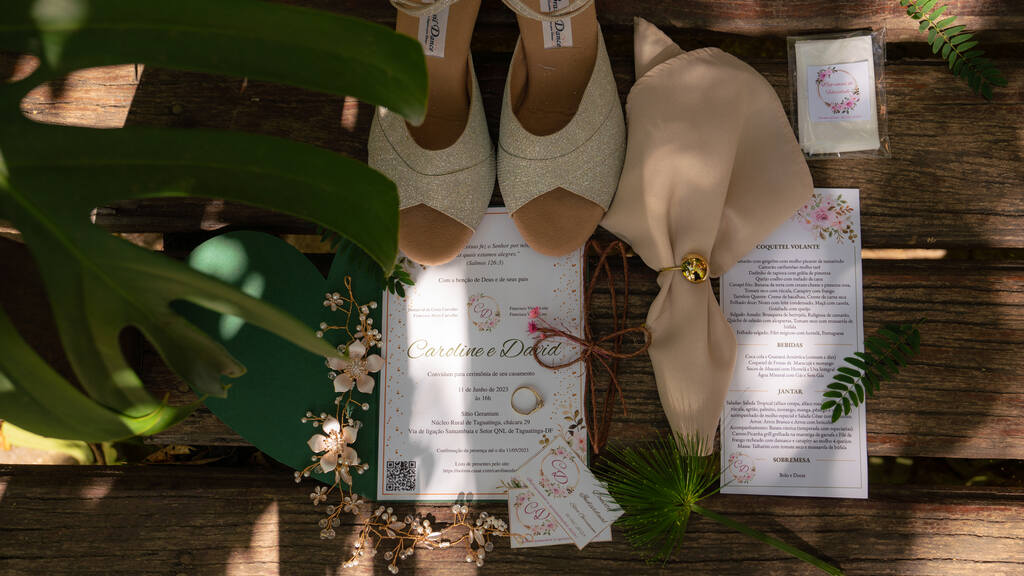 sandália bege ao lado de guardanapo rosê e convite de casamento branco