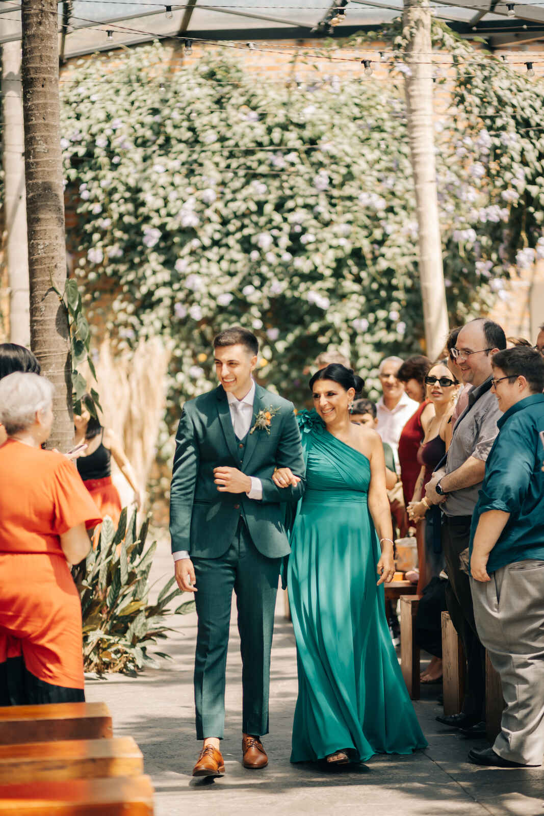 entrada da noivo com tenro verde ao lado da mãe com vetsido verde com ombro único