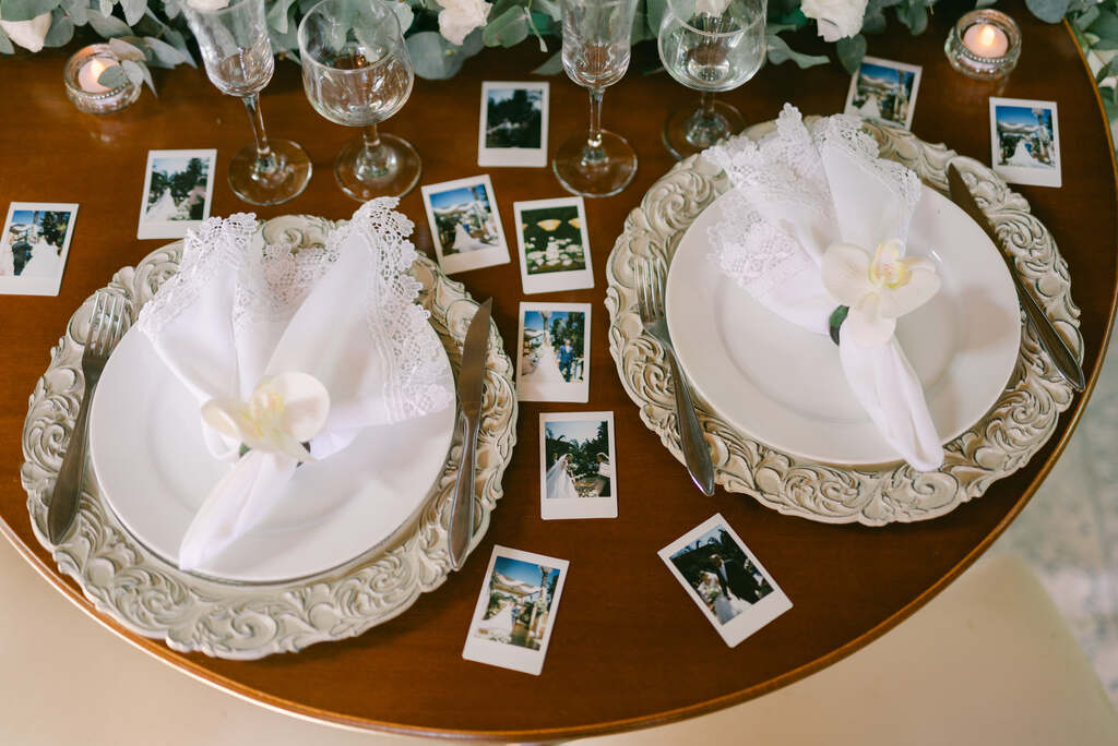 mesa posta com sousplat elegante e ao redor com fotos instantaneas