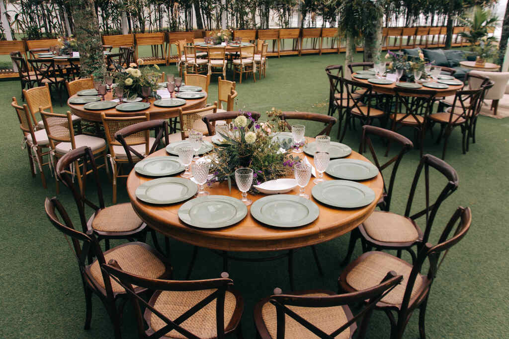 salão com gramado artificial com mesas postas decoradas