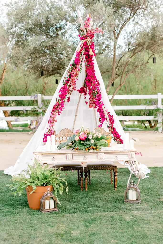 tenda decorada com flores sob pequena mesa clássica antiga no campo