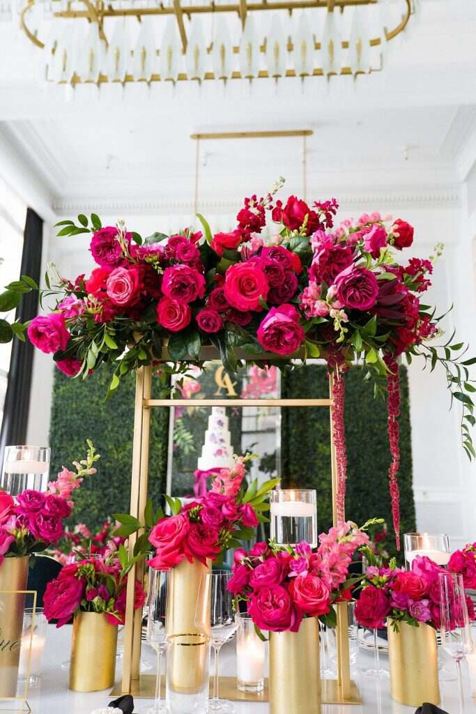 casamento fucsia com mesa decorada com vasos dourados e flores