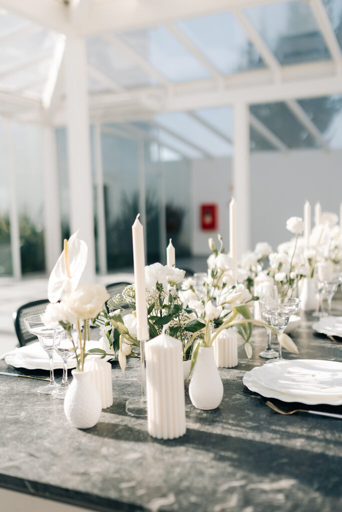 mesa posta com mini vasos brancos minimalista com flores brancas