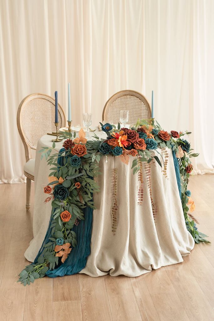 mesa dos noivos redondas com toalha branca e tecido decorativo azul e flores em cima laranja vermelho e azul