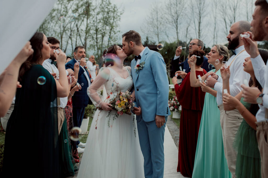 saida dos noivos com beijo em casamento no campo