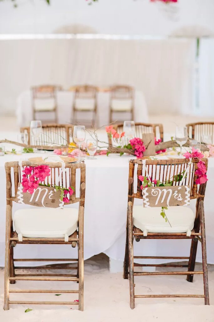 cadeira dos noivos decorada com placa de madeira escrito mr e ms com flores rosas