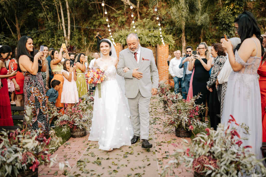 entrada da noiva com o pai com tenro cinza e gravata vermelha