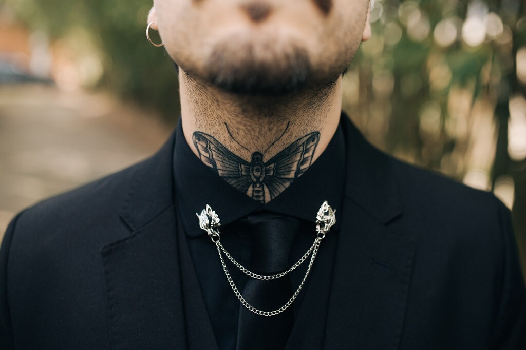 noivo com camisa gravata colete e terno preto com pingente prata na gola da camisa