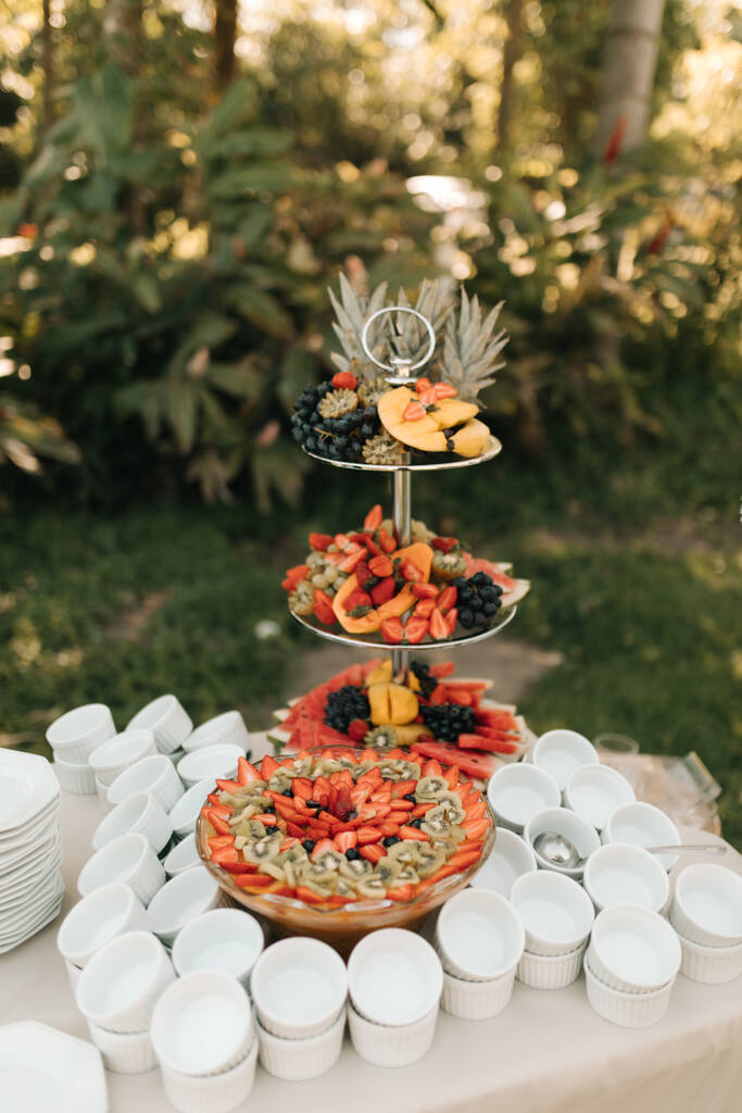 mesa com pratos e copo e torre com frutas