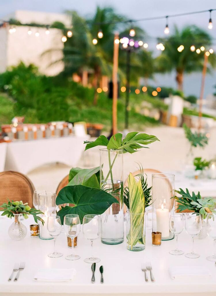 decoração de casamento praiano com centro de mesa com garrafas de vidro e plantas