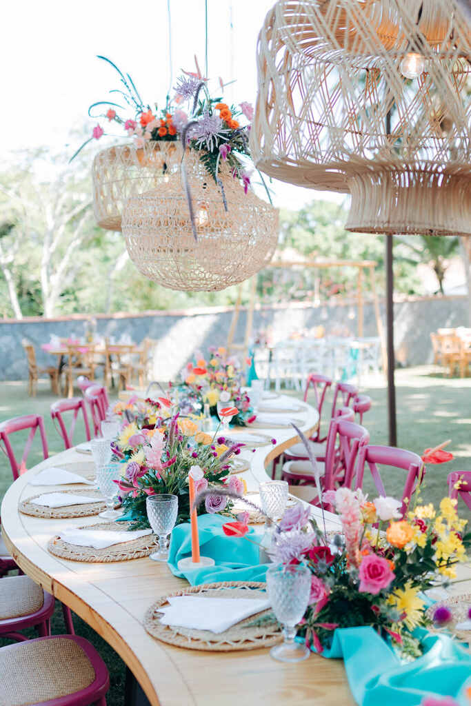 decoração de festa de casamento na praia com centro de mesa colorido e cadeiras na cor pink