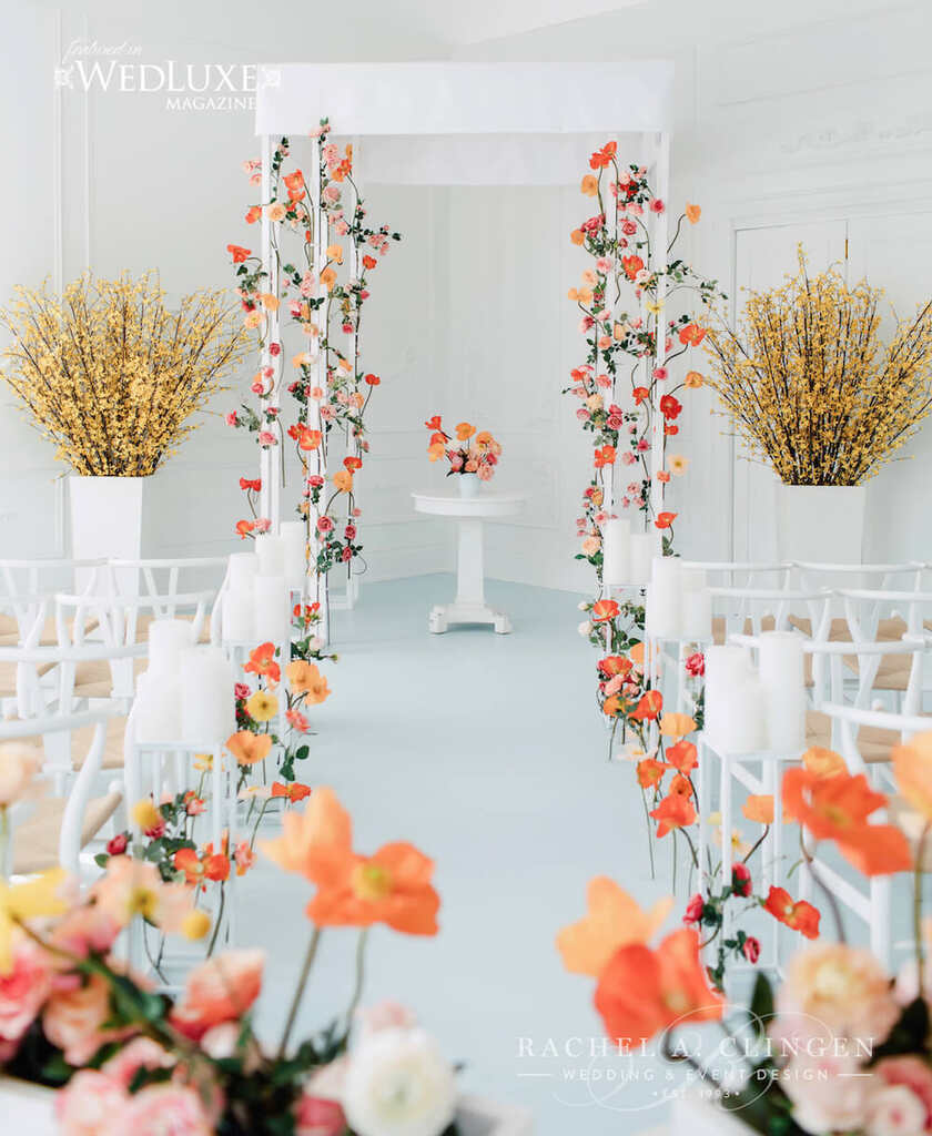 altar minimalista em salão branco com flores brancas laranjas e amarelas