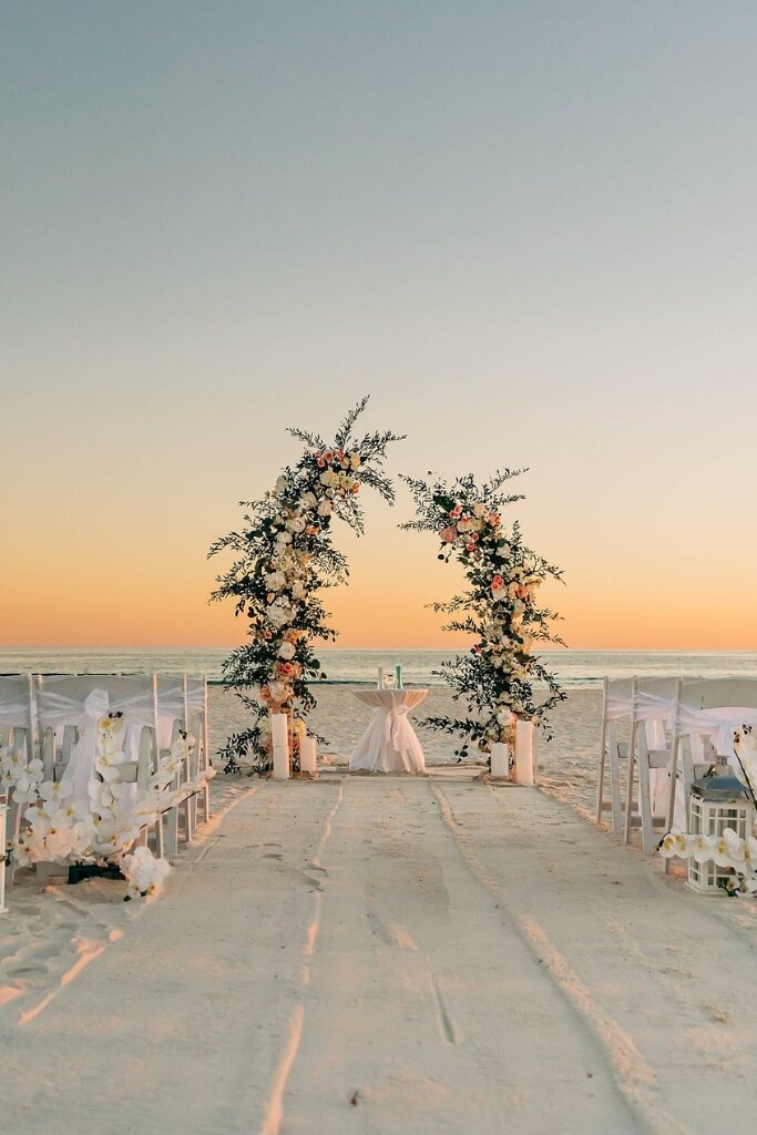 decoração de casamento na praia com altar desconstruído ao por do sol