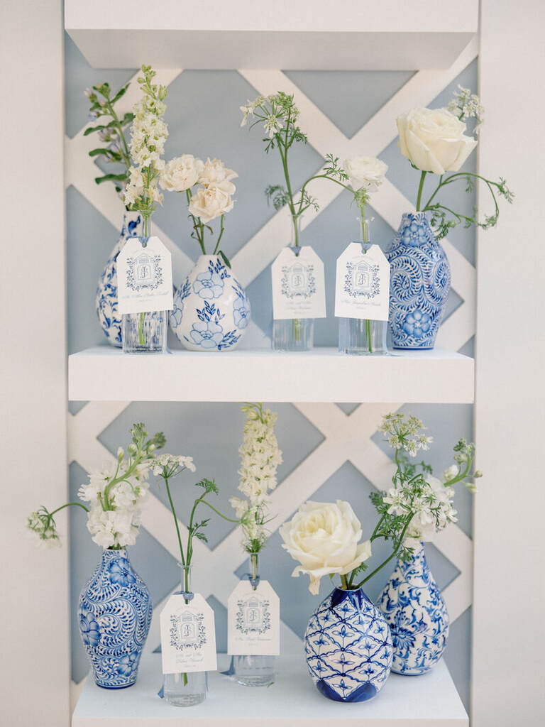 prateleira com vasos brancos e azuis com flores brancas
