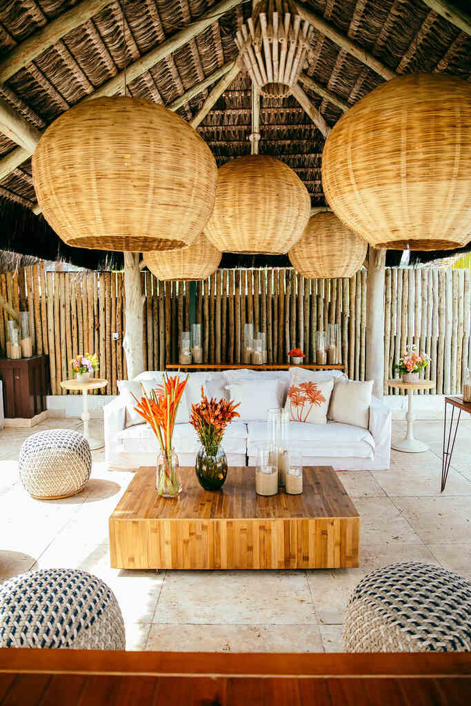 decoração de casamento na praia com lounge com sofá branco e luminarias de palha
