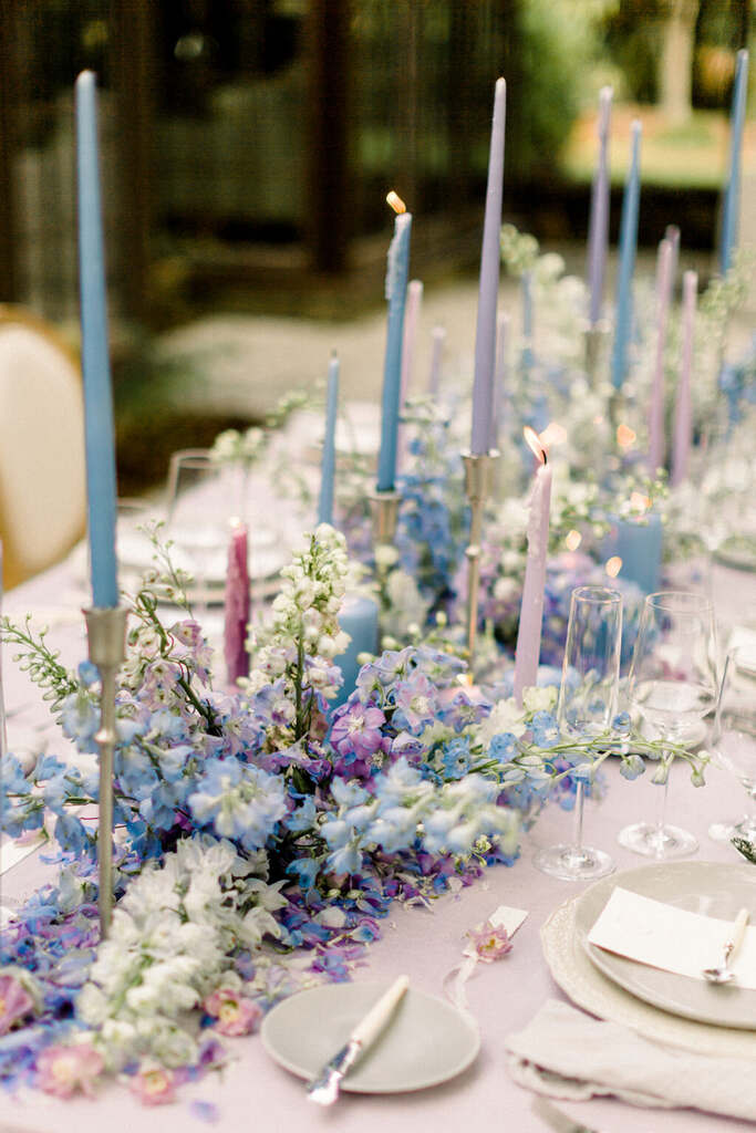 centro de mesa com flores azuis e velas liláses