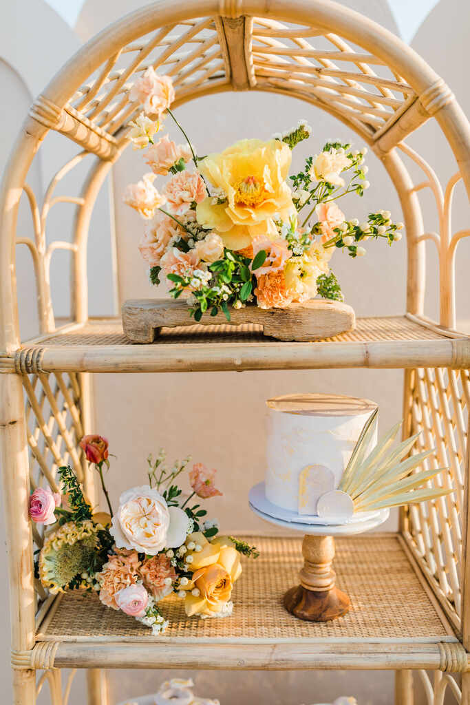 estante boho com flores amarelas e bolo de casamento branco minimalista