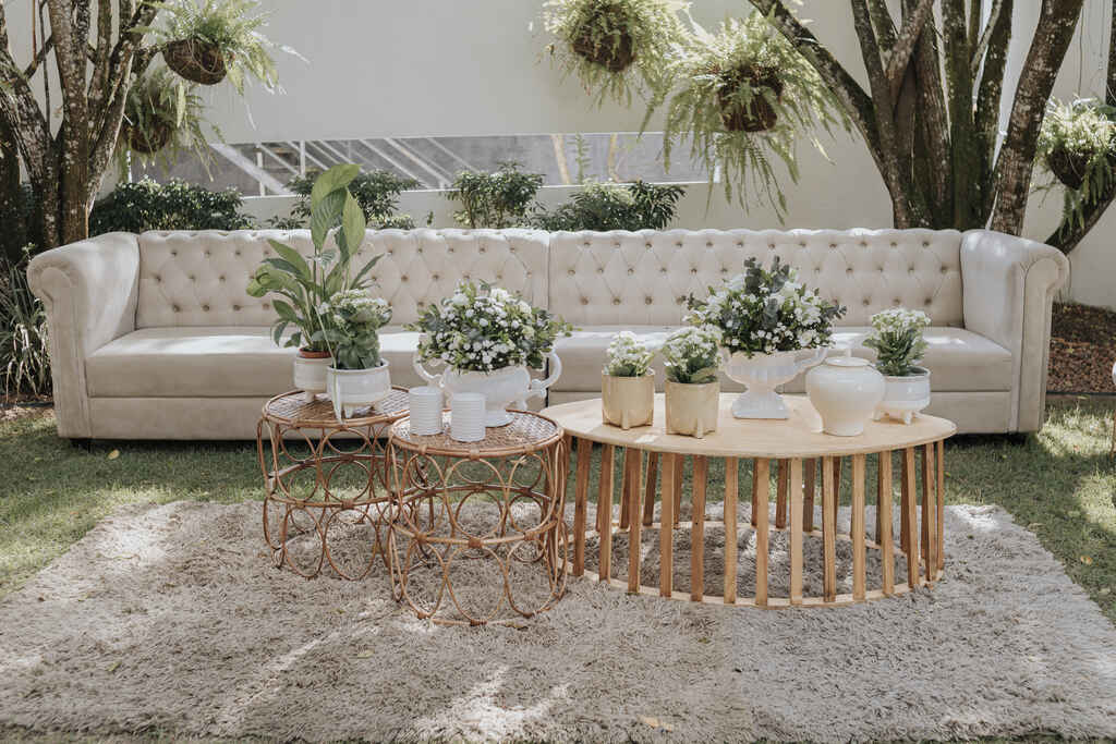 lounge com sofá branco clássico no gramado e mesas de centro de madeira