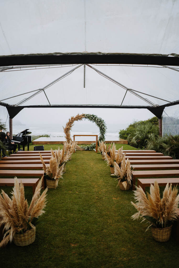 espaço para cerimonia de casamento ao ar livre com tenda de cristal com altar com capim dos pampas