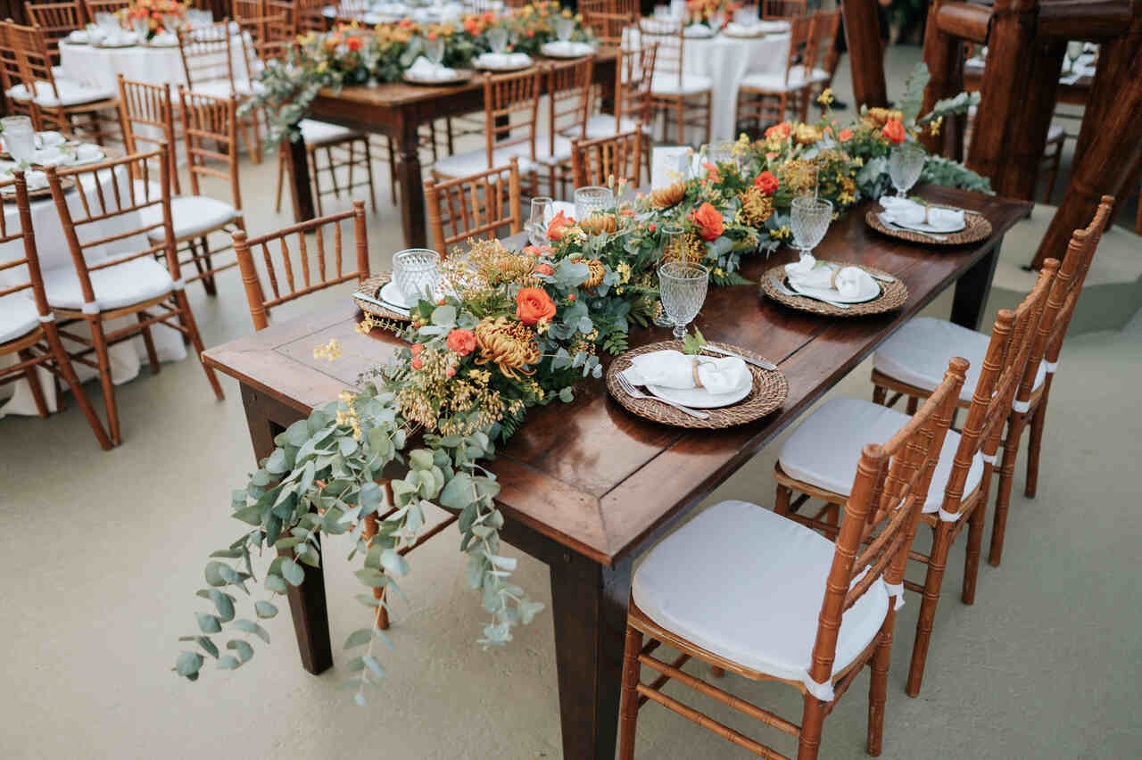 mesa posta com centro de mesa com folhas de eucalipto e flores terracota