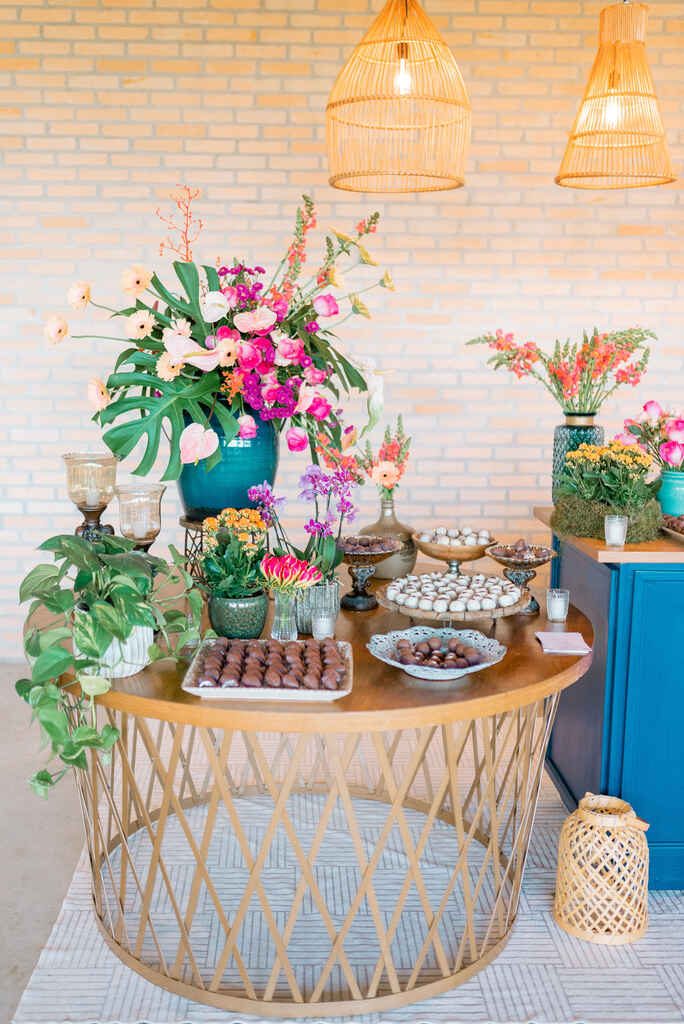 mesa com doces de casamento e vasos com flores