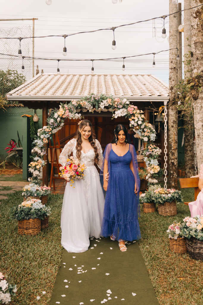 entrada da noiva com buquê colorido com a mãe usando vestido azul clássico