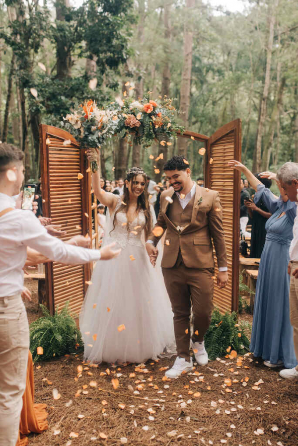 capa post: saída dos noivos sob pétalas de flores laranja