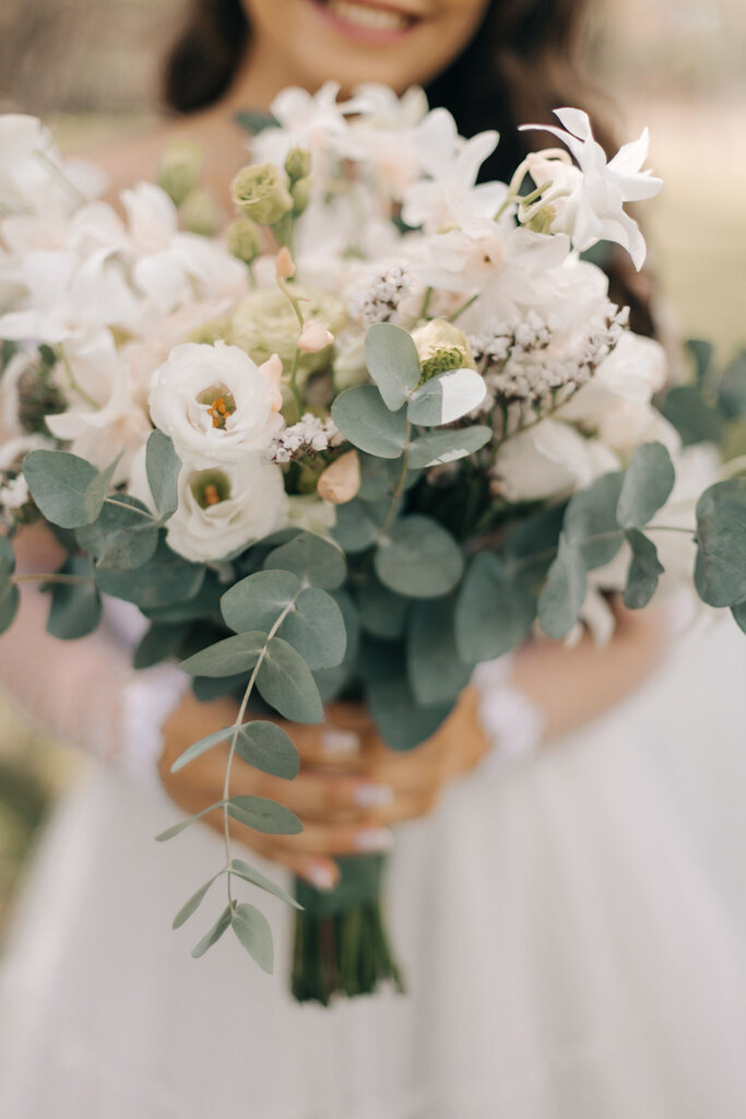 noiva segurando buquê com flores brancas