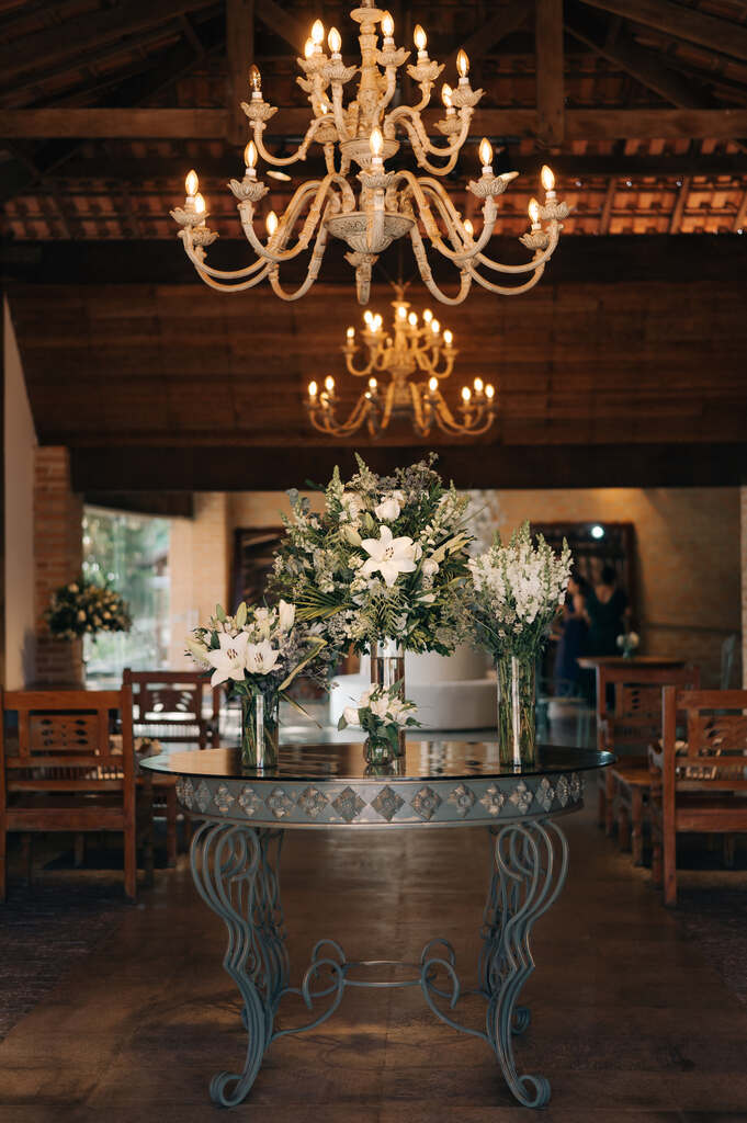 salão rpustico e elegante com mesa central com vasos com flores