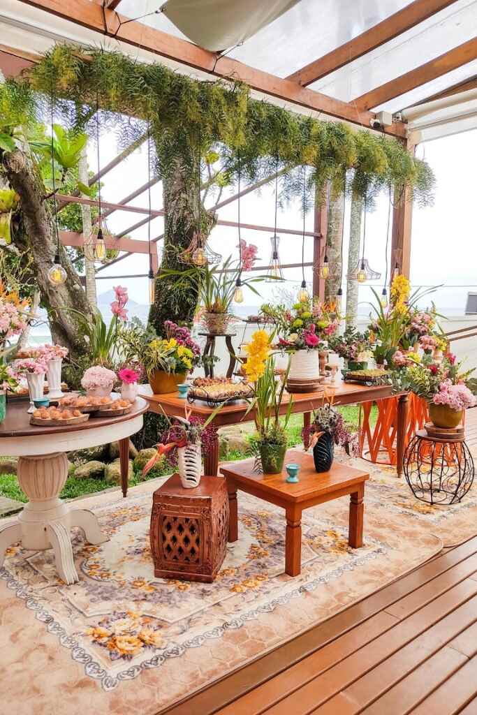salão ao ar livre com mesas com vasos com flores e doces de casamento