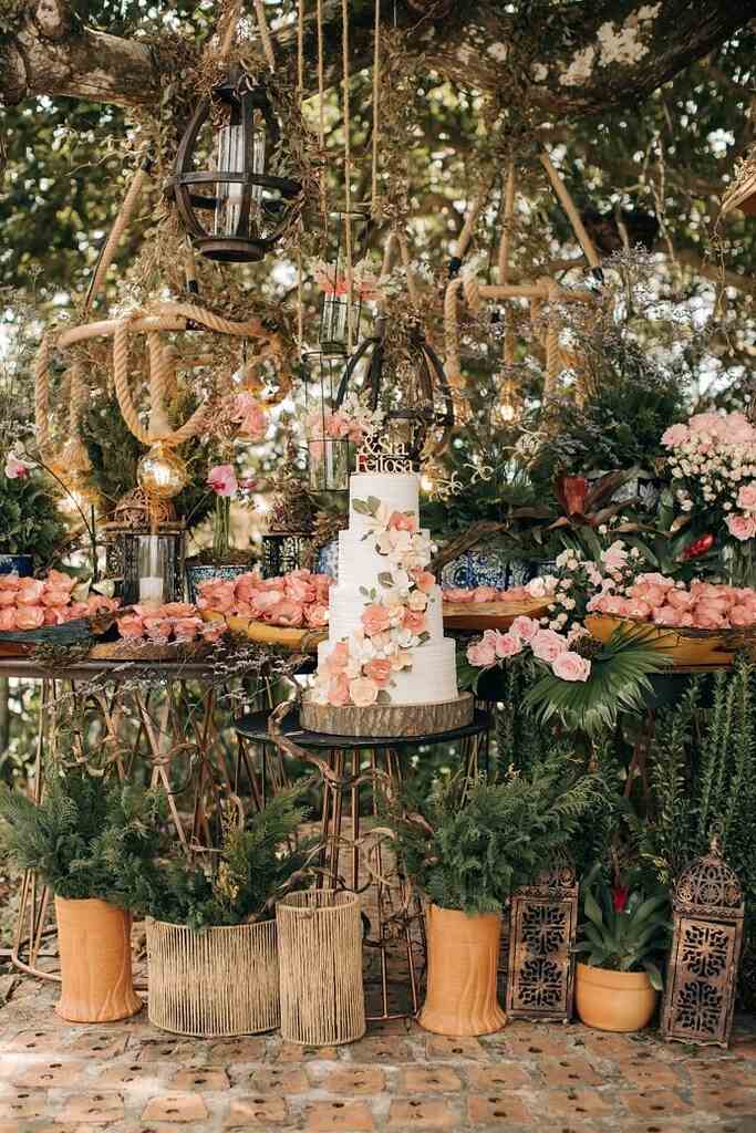 mesa com doces de casamento com flores rosas