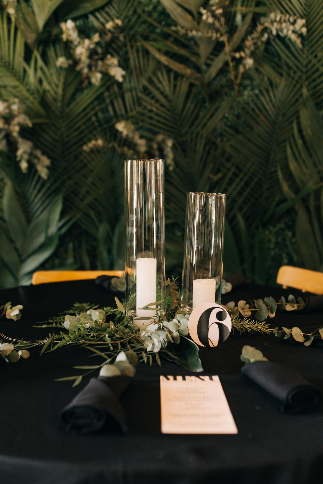 centro de mesa com porta velas de vidro em mesa posta preta