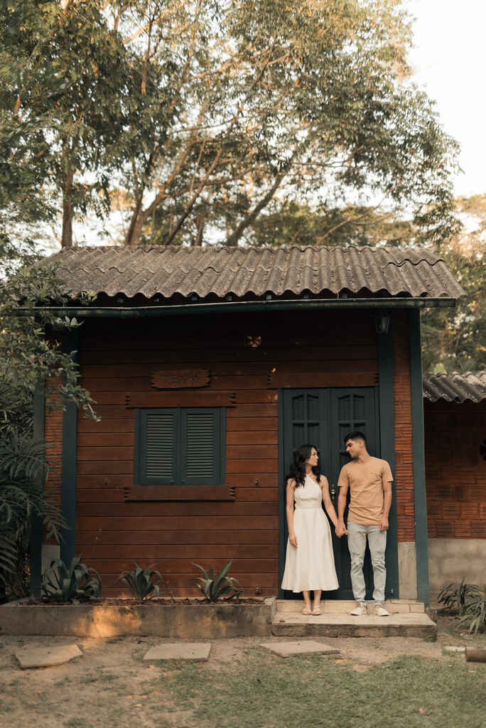 casal na frente de cabana de madeira
