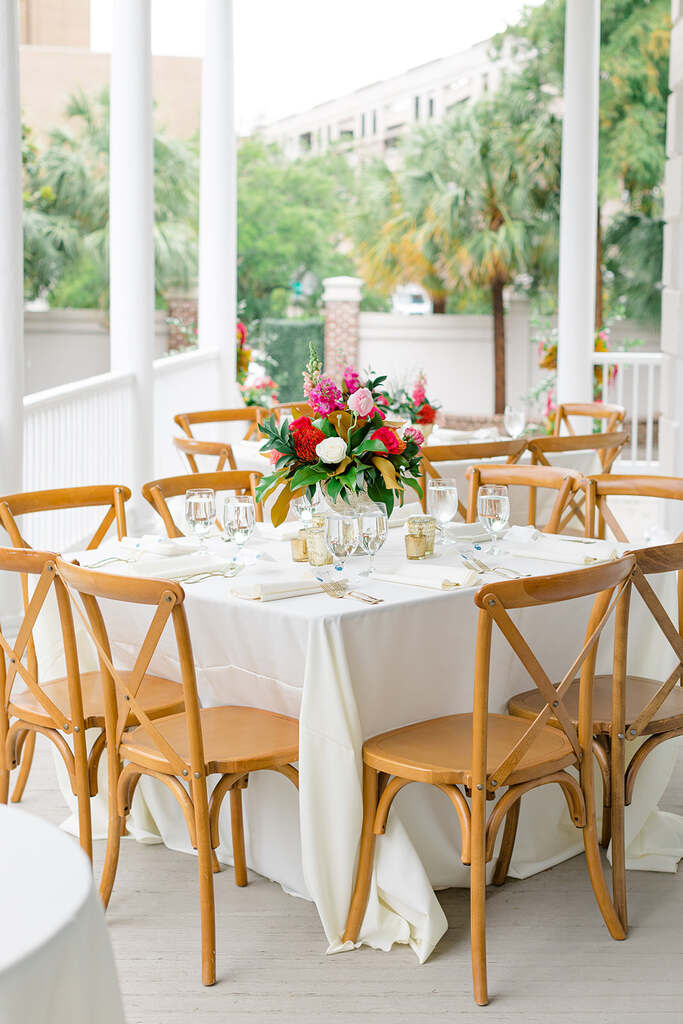 decoração durante o dia para casamento com mesa quadrada posta com vaso de flores coloridas no centro