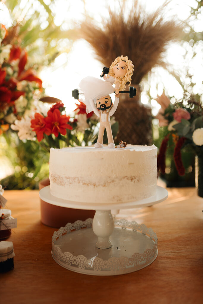 bolo de casamento branco com bonecos de noivos no topo
