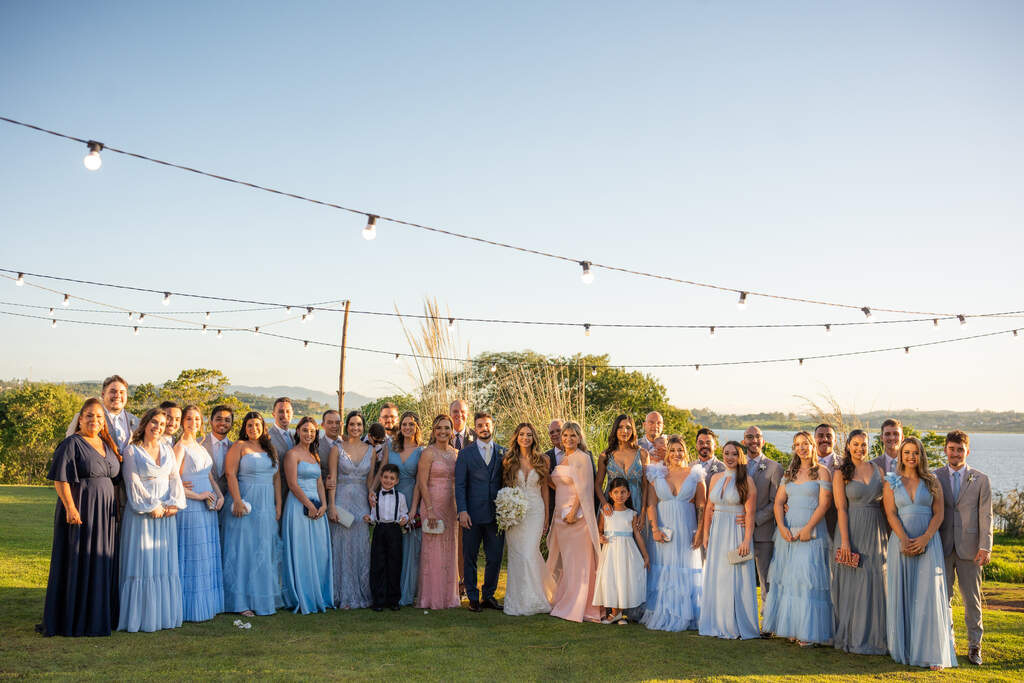 noivos ao lado das madrinhas com vestido azul serenity mães com vestido cor de rosa e padrinhos com terno cinza