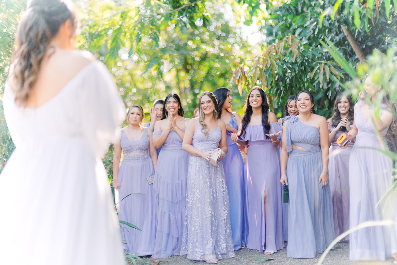 madrinhas com vestidos na cor lavanda reagindo ao ver a noiva pela primeira vez
