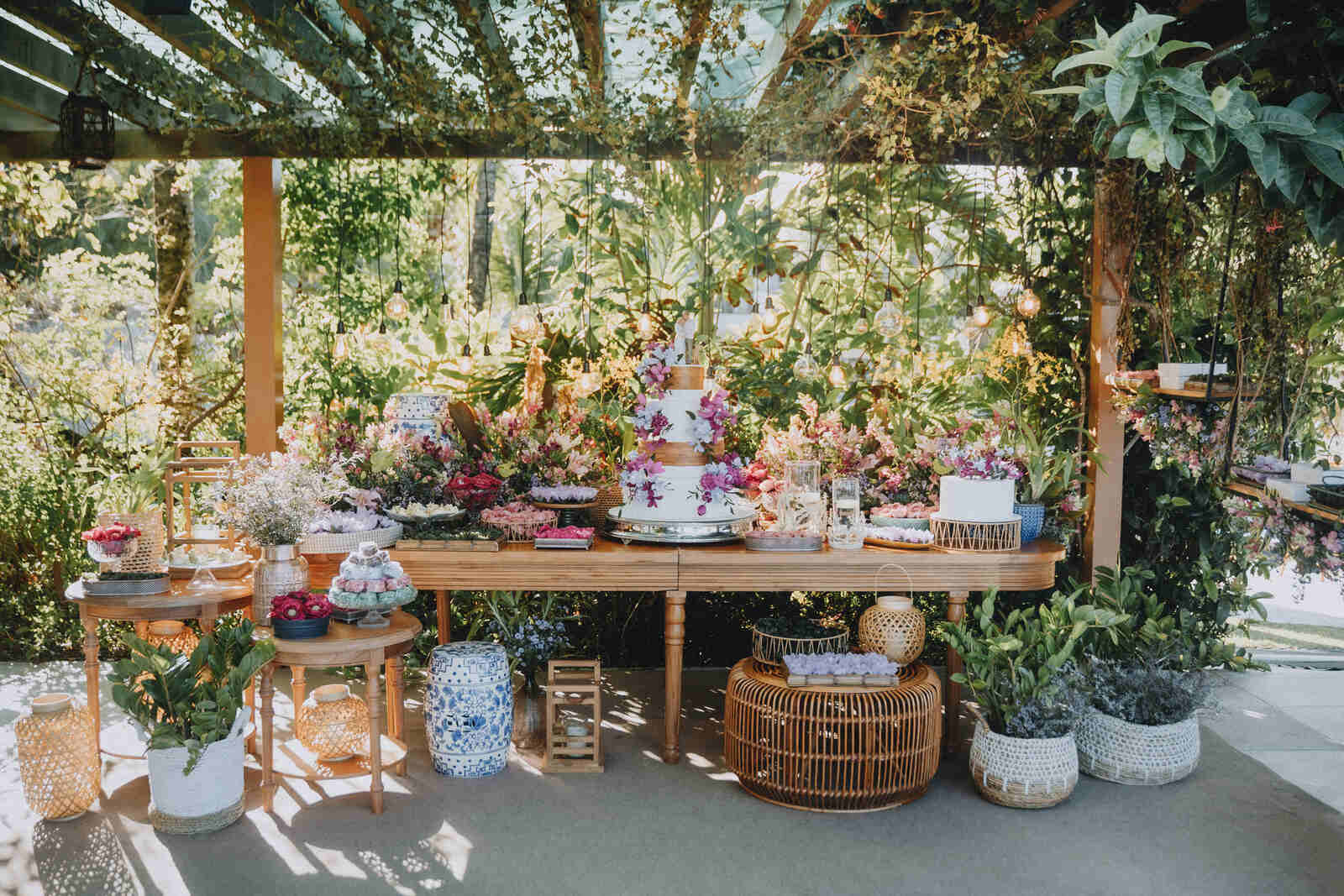 mesa para bolo de casamento com flores lilás com e bandejas com doces