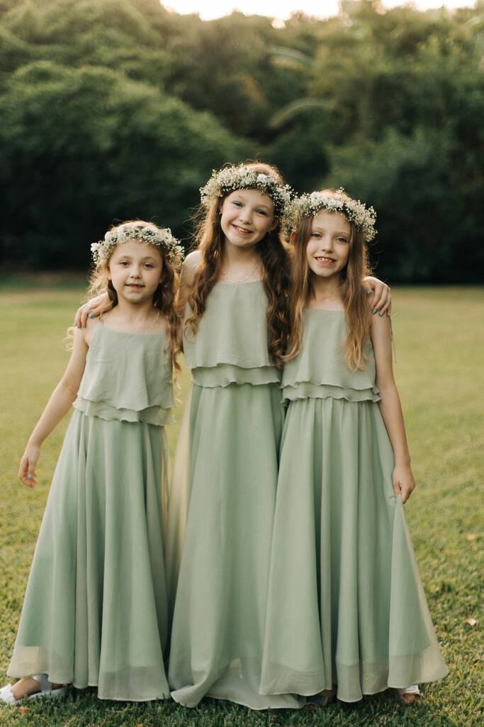 três daminhas com vestido verde sage com coroa de flores brancas