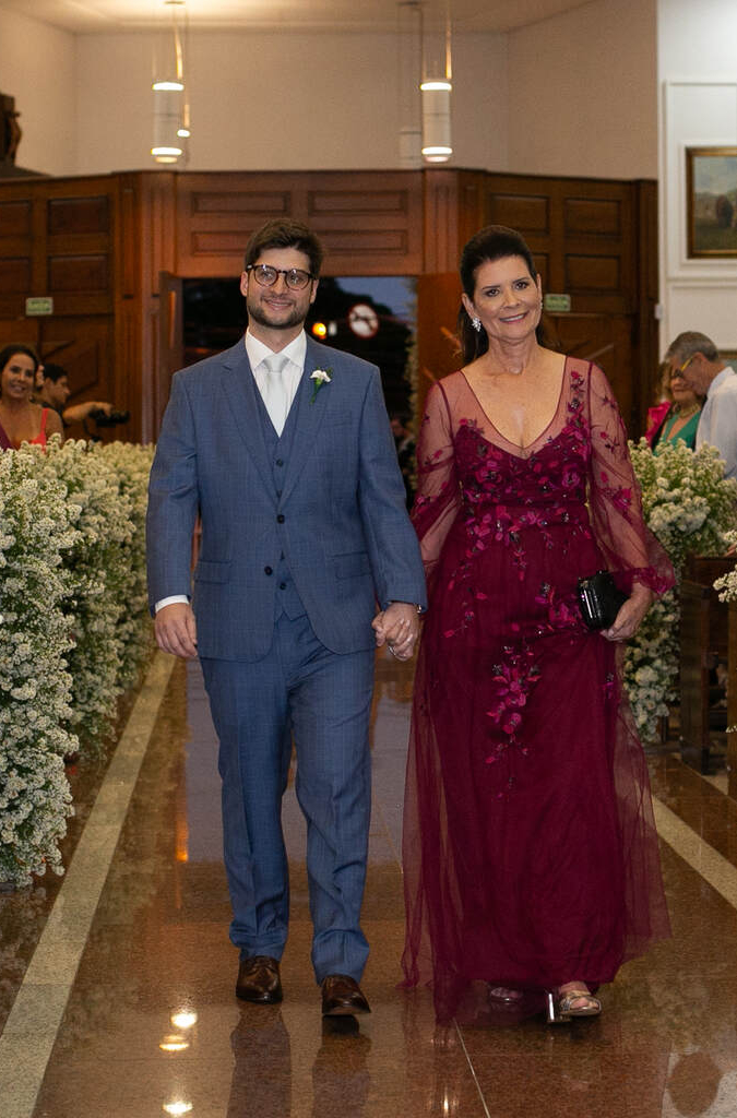 entrada do noivo com tenro azul com a mãe com vestido vinho com manga longa