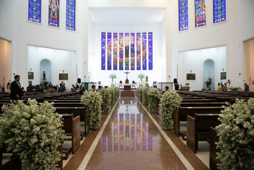 igreja com vitrais coloridos decorada com flores brancas