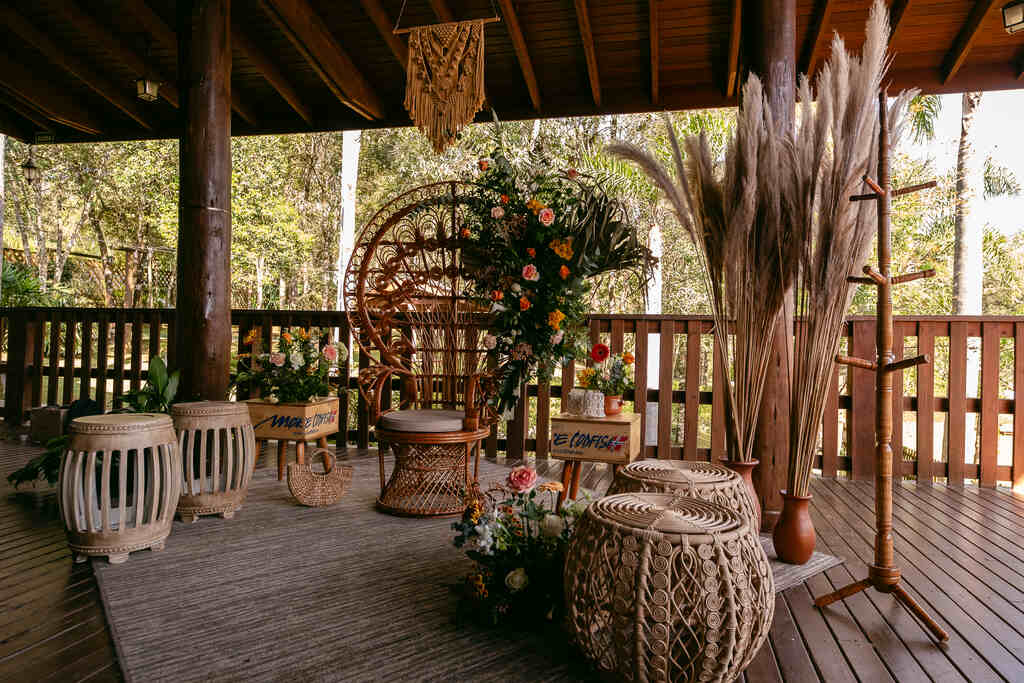 cadeira emanuelle dos noivos decorada com flores rosas e laranjas na varanda
