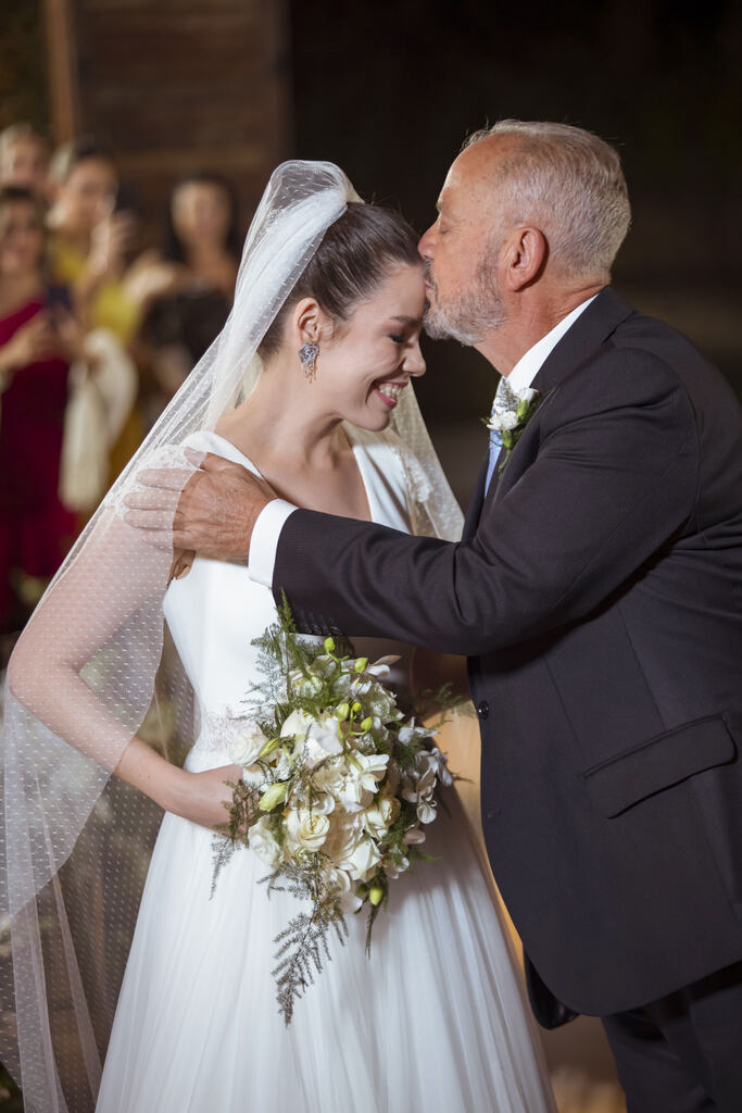 pai da noiva com terno preto beijando a testa da noiva
