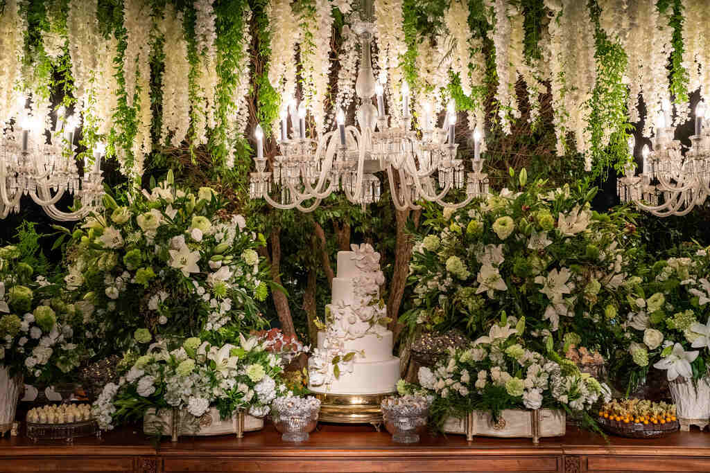 mesa do bolo clássica com bolo de casamento com quatro andares e topo de flores