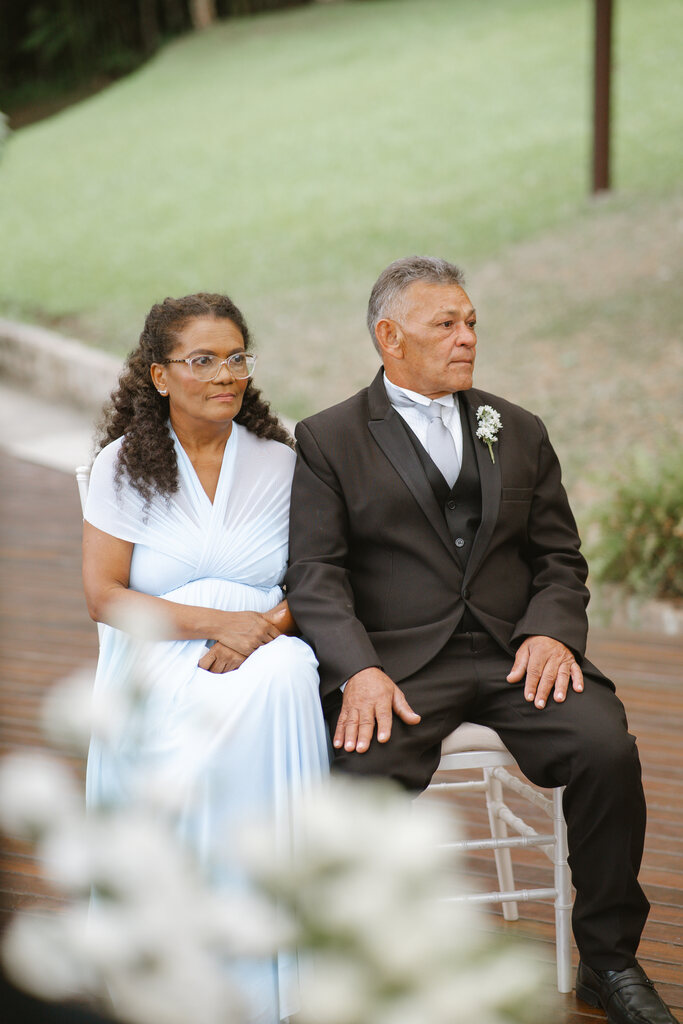 pais do noivo sentados ao lado do altar