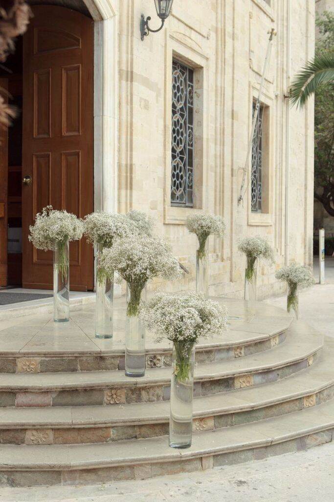 escada na frente da igreja com vasos de vidro com flo mosquitinho