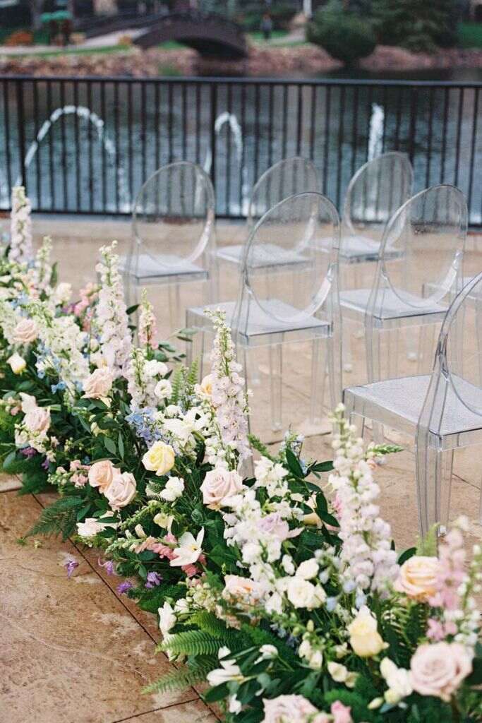 rosas e flores coloridas ao lado de cadeiras de acrilico transparente