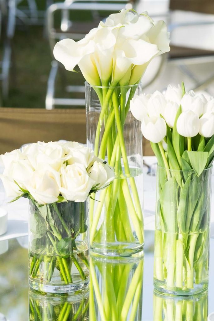decoração de casamento de dia elegante com centro de mesa vasos com tulipas e rosas brancas