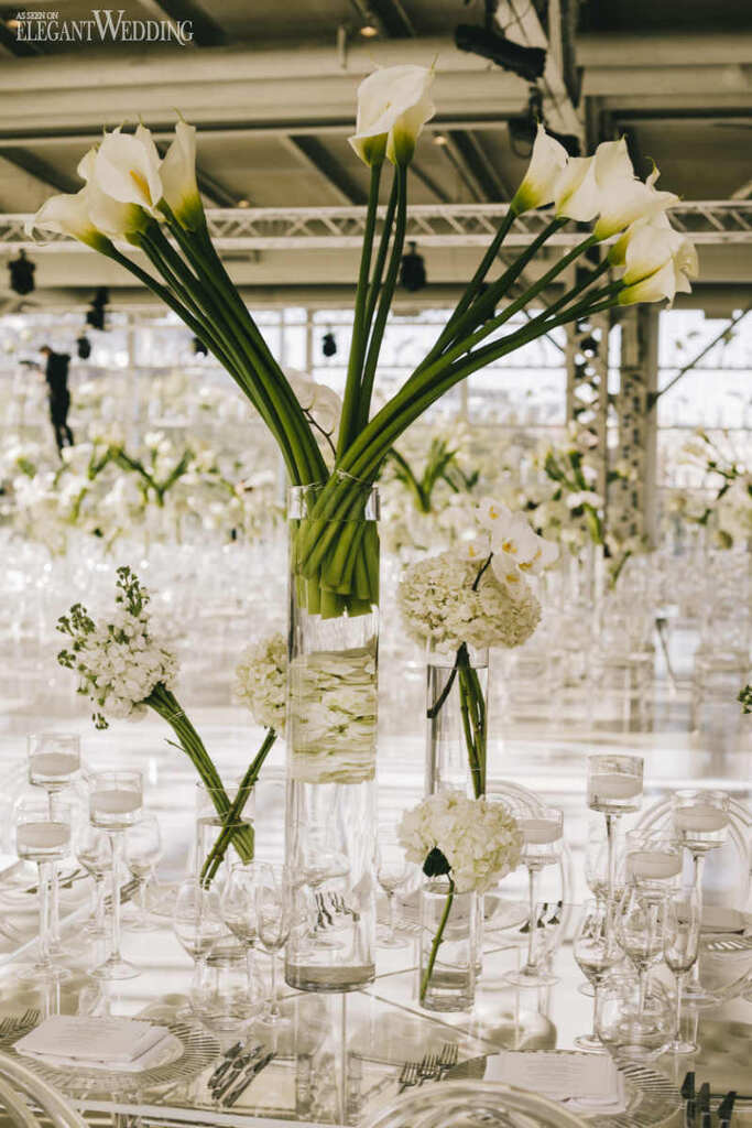 mesa posta elegante com vasos de vidro com callas brancas